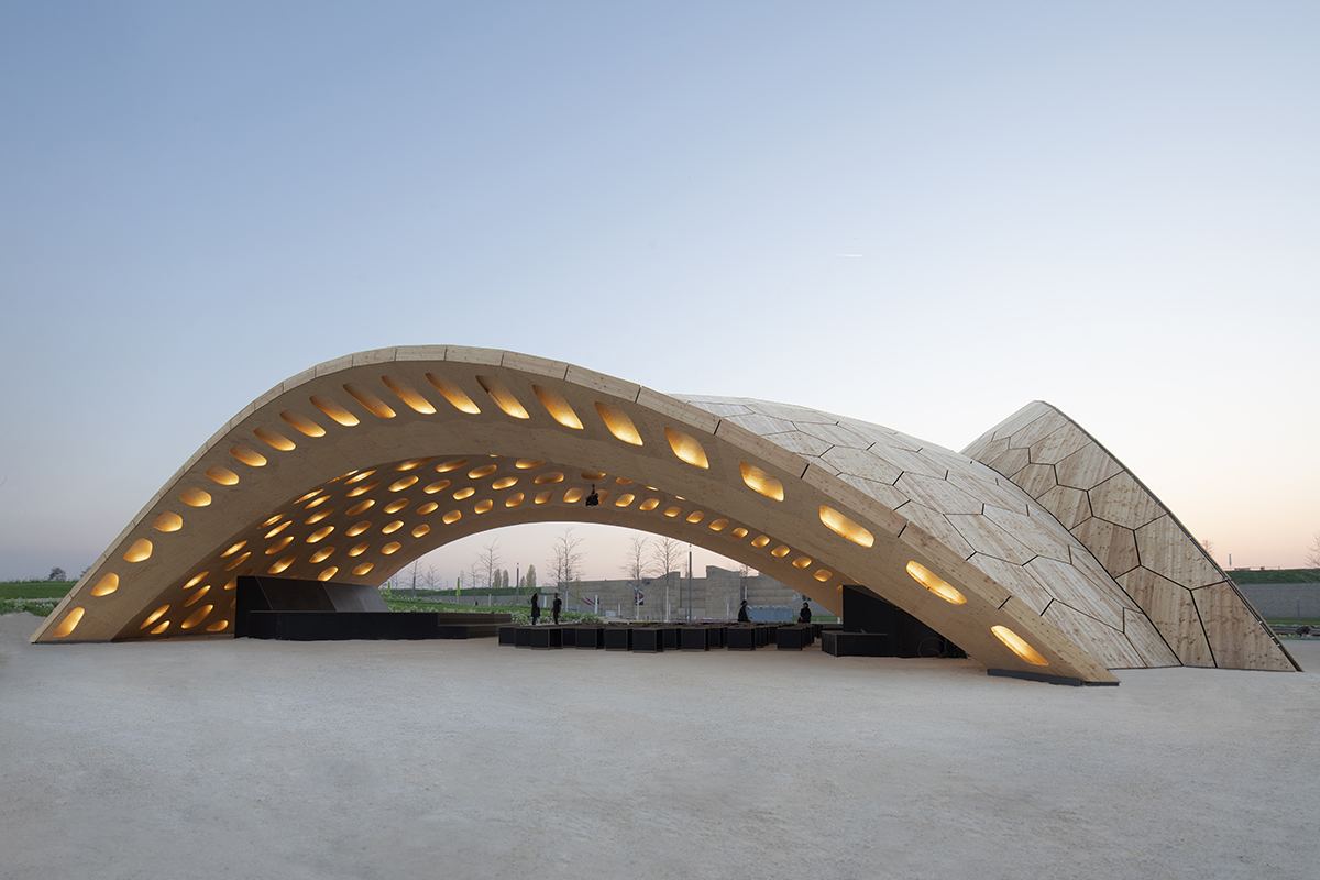 BUGA Wood Pavilion: Timber shell spanning over the event venue at dusk