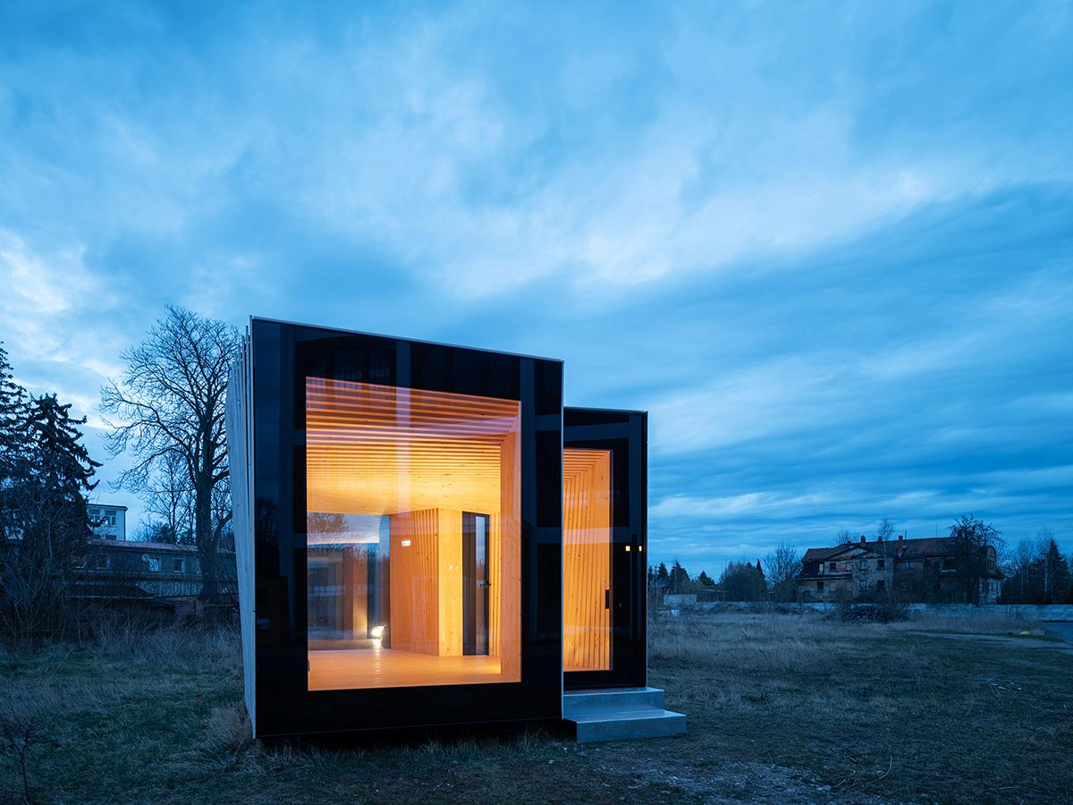 IBA Timber Prototype House: Prototype house in a field at dusk