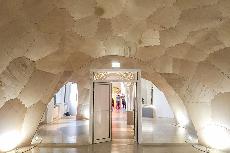 Segmented Timber Shell: Plywood shell framing the museum doorway